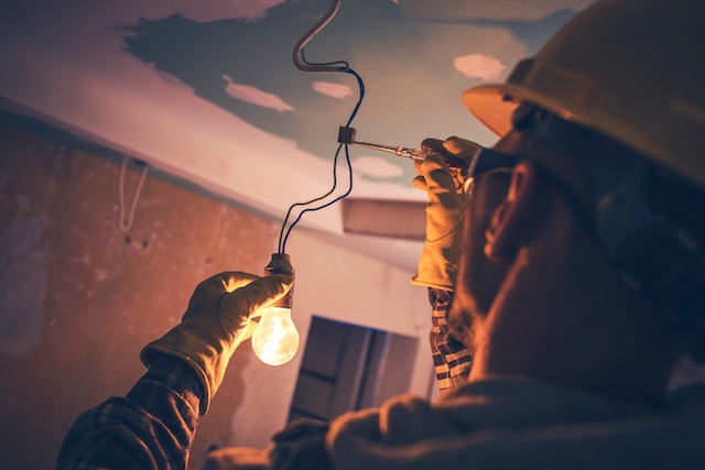 Working Contractor Electrician. Fixing the Light after getting a call through electrician marketing